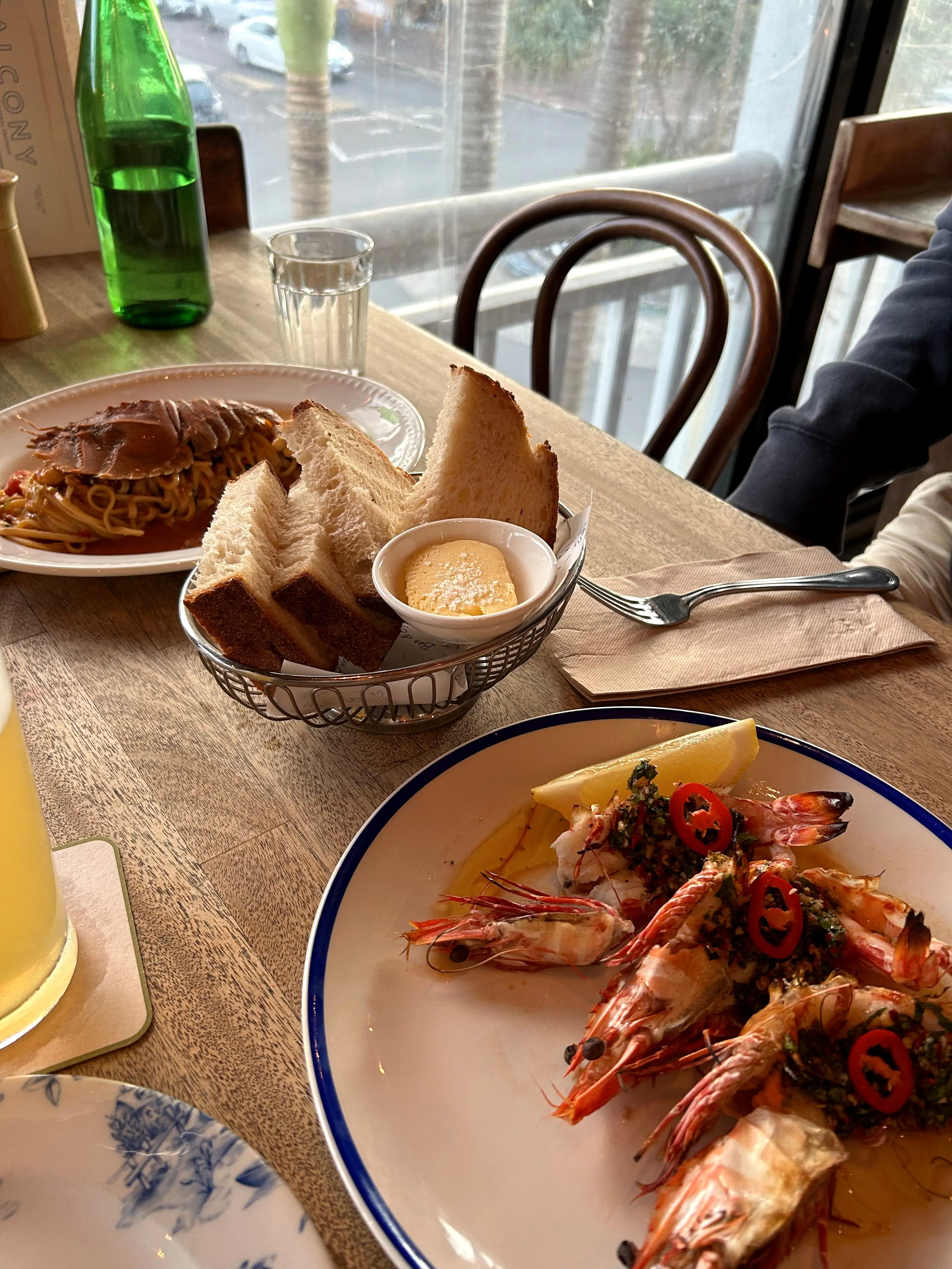 A plate of chilli-and-herb prawns with crusty bread and butter by the window at Balcony Bar
