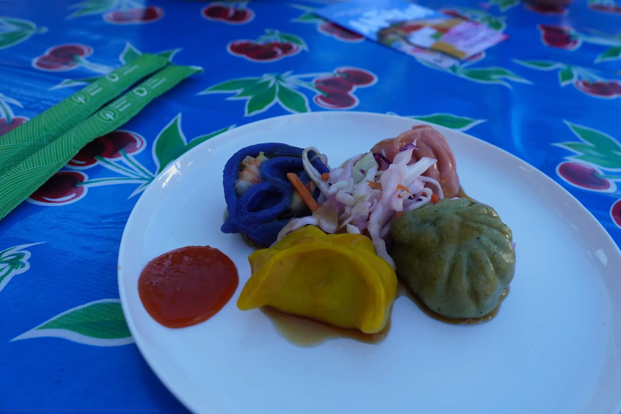 A colourful plate of handmade Radiance Kitchen dumplings with slaw and chilli sauce at the Mullum Farmers Market
