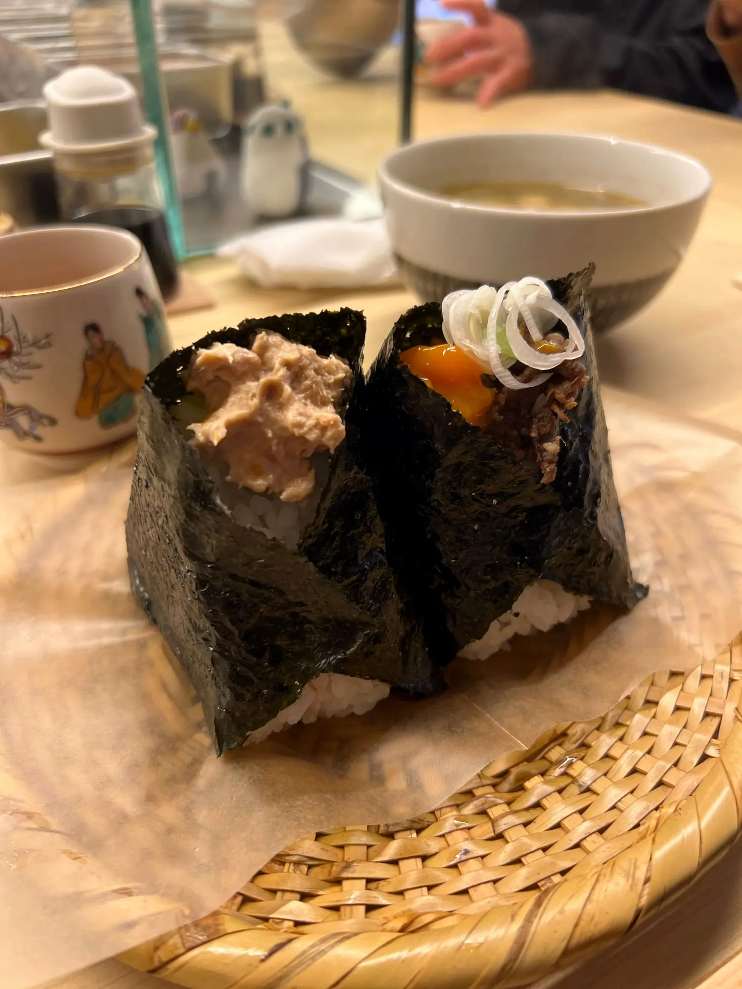 Two onigiri shown open — one with tuna mayo, one with beef and a soft egg yolk